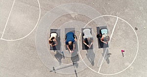 Aerial, drone footage of group of well-trained men and women doing exercises