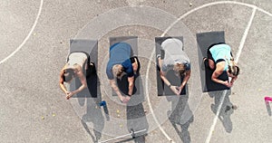 Aerial, drone footage of group of well-trained men and women doing exercises