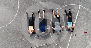 Aerial, drone footage of group of well-trained men and women doing exercises