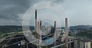 Aerial drone footage of a large coal power plant station with cooling towers chimney and boiler house in an air