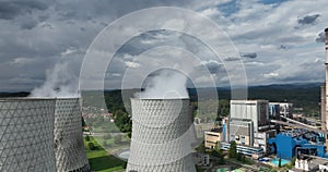 Aerial drone footage of a large coal power plant station with cooling towers chimney and boiler house in an air