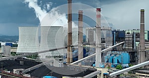 Aerial drone footage of a large coal power plant station with cooling towers chimney and boiler house in an air