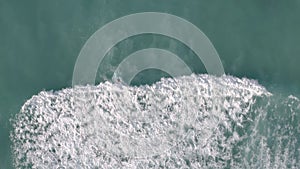 Aerial, drone footage of a lone surfer riding Pacific waves near Waikiki Beach in Oahu