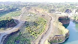 Aerial drone glides over an abandoned mine, capturing the eerie beauty of nature reclaiming manmade structures in Ranu