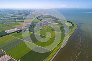 Aerial drone image of typical Dutch farmland, polder, near lake and windmills
