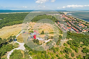 Aerial drone image of Vlieland. With bright red Lighthouse on top of a dune overlooking the town and the Wadden Sea photo