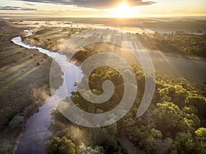 Aerial drone landscape of river in green field