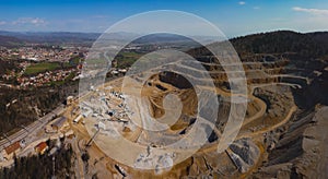 Aerial drone panorama of an open mine or quarry on a sunny day at Verd, Slovenia. Visible terraces and vast surface of sand and photo