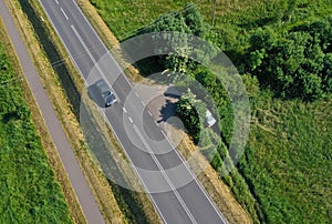 Aerial drone perspective view on car accident hitting the bushes and roadside, high speed on curve causing the car to fell of the