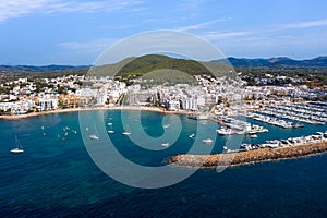 Aerial drone photo of the beautiful island of Ibiza in Spain showing the costal front golden sandy beaches with people relaxing