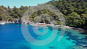 Aerial drone photo of pleasure yacht anchored in crystal clear bay and turquoise beach. uninhabited island in