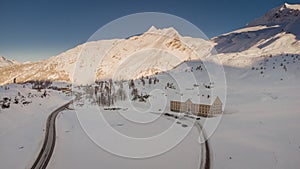 Aerial drone photo of Simplon hospiz on the top of the simplon pass covered in winter snow. House surrounded with large amount of