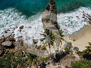 Aerial drone photo of tropical beach, sea rocks, turquoise ocean and palm trees. Atuh beach, Nusa Penida island, Bali