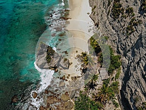 Aerial drone photo of tropical beach, sea rocks, turquoise ocean and palm trees. Atuh beach, Nusa Penida island, Bali