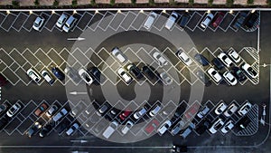 Aerial drone photography of parking lot with cars parked and free space available at night. Transportation car park