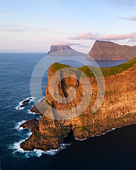 Kallur lighthouse on green hills of Kalsoy island photo