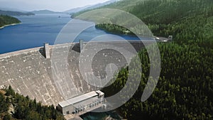 Aerial drone of the river, dam, reservoir, mountains and dense coniferous forest