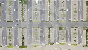 Aerial drone, road and empty parking lot in city for driving, stop signs and lines of asphalt above. Top view of street