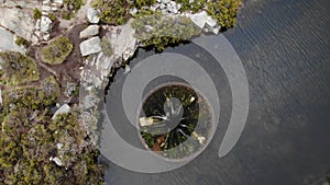 Aerial drone rotating over big sinkhole constructed as a water spillway at Covao dos Conchos dam lake in Serra da