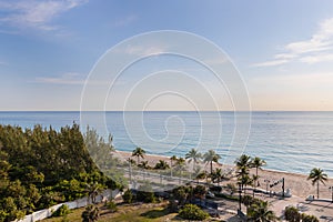 Aerial drone shoot in florida tropical coast showcasing commercial areas, blue sky and beach