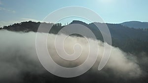 Aerial drone shot of amazing dense fog above river between mountains.