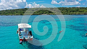 Aerial Drone Shot of Boat with Snorkelers out on the coral reef in Menjangan island, Bali, Indonesia