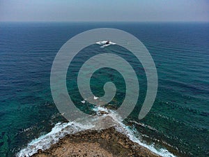 Aerial drone shot of cargo shipwreck in Paphos with waves Cyprus island storm Mediterranean sea