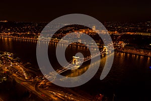 Aerial drone shot of Chain bridge over Danube and National Gallery with lights in Budapest night