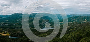 Aerial drone shot of Donner lake with a landscape view, green mountains and cloudy sky background