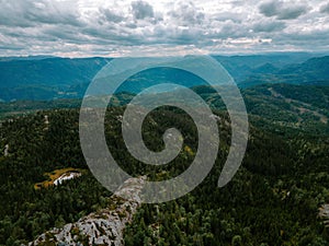 Aerial drone shot of Donner lake with a landscape view, green mountains and cloudy sky background