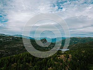 Aerial drone shot of Donner lake with a landscape view, green mountains and cloudy sky background