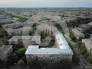 Aerial drone shot of downtown with house with new silver roof in the front. Summer day in Magnitogorsk, Russia