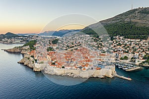 Aerial drone shot of Dubrovnik city wall in Adriatic sea in Croatia summer with view of Mountain Srd before sunrise