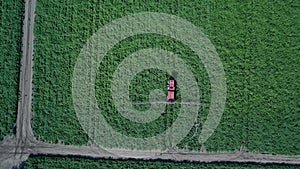 Aerial drone shot of farm machinery spraying agriculture fields in the Suffolk countryside before they harvest