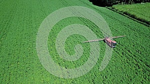 Aerial drone shot of farm machinery spraying agriculture fields in the Suffolk countryside before they harvest