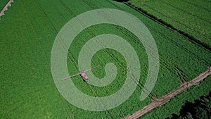 Aerial drone shot of farm machinery spraying agriculture fields in the Suffolk countryside before they harvest