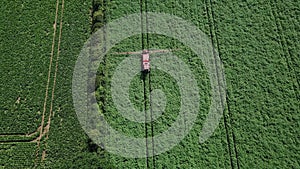 Aerial drone shot of farm machinery spraying agriculture fields in the Suffolk countryside before they harvest