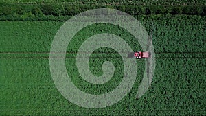 Aerial drone shot of farm machinery spraying agriculture fields in the Suffolk countryside before they harvest