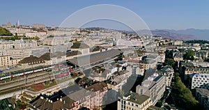 Aerial drone shot flying above the train station of Lausanne Switzerland with lake Geneva in the background