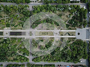 Aerial drone shot of green park in city downtown at sunny day