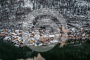 Aerial drone shot of market place outside village church near ferry dock in Hallstatt in Austria in winter