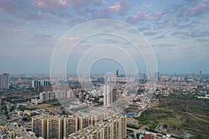 aerial drone shot passing over a building with homes, offices, shopping centers moving towards skyscapers in front of photo