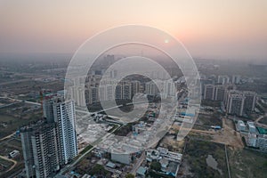 aerial drone shot passing over a building with homes, offices, shopping centers moving towards skyscapers in front of photo