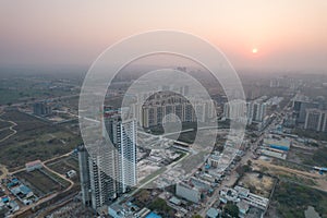 aerial drone shot passing over a building with homes, offices, shopping centers moving towards skyscapers in front of photo