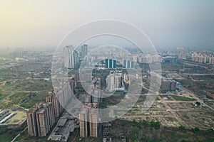 aerial drone shot passing over a building with homes, offices, shopping centers moving towards skyscapers in front of photo