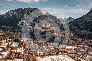 Aerial drone shot of picturesque Neuschwanstein Castle on snowy hill in winter sunlight in Germany