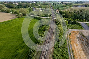 aerial drone shot of a railroad in between rural fields and vegetation