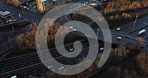 Aerial drone shot reveals spectacular highway and convergence of roads, bridges, viaducts in Glasgow at sunset, transportation and