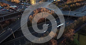 Aerial drone shot reveals spectacular highway and convergence of roads, bridges, viaducts in Glasgow at sunset, transportation and