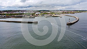 Aerial drone shot reversing upwards over Seaham Harbour and lighthouse